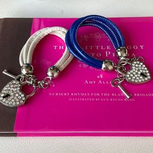 Two lock and key bracelets, one blue and one white banded. Rhinestone details